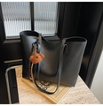 Detail of black faux leather tote bag with brown plush bear charm and striped strap - Black (With Charm)