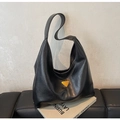 Detail shot of black pebbled leather tote bag featuring a yellow triangular logo - Black