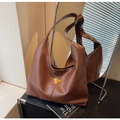 Detailed view of large brown faux leather tote with golden triangular metal logo detail - Brown