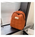 Detail shot of the orange quilted backpack featuring black zippers and a square patch - Orange