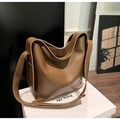Detalle de un bolso hobo grande de cuero marrón con correa ancha y logotipo dorado - Caqui