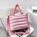 Rosa gesteppte Puffer-Tasche mit Umhängeriemen auf einem modernen weißen Stuhl - Rosa