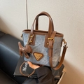 Blue denim bucket bag with brown leather trim, gold logo plaque, and pony charm - Blue with Charm