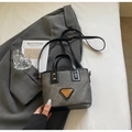 Sac seau gris avec finitions en cuir noir et logo doré dans un décor élégant - Brun Thé Foncé (Sans Pendentif)