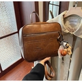 Detalle de mochila vintage de cuero marrón con oso de peluche y colgantes de baloncesto - Marrón con colgante
