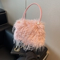 Pink faux feather bucket bag with pearl details and a gold chain strap on a sofa - Pink
