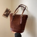 Bolso cubo de ante mate marrón oscuro con costuras de cuero y hebillas doradas - Marrón