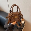 Mini bolso tipo almohada de charol marrón con colgante deportivo y herrajes oro - Con Colgante / Marrón
