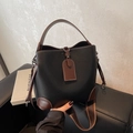 Schicke Eimertasche aus schwarzem Lychee-Leder mit braunem Rand und breitem Webgurt - Schwarz