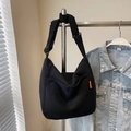 Bolso tote de pana negra con correa ajustable y etiqueta naranja colgado en estante - Sin colgante / Negro