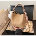 Detail of light brown bucket bag with silk scarf handle and plush ball charm in gift box - Khaki with Pendant