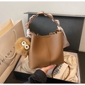 Detail of brown litchi pattern bucket bag with floral scarf handle and plush charm - Brown with Pendant