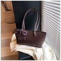 Detalle de bolso tote de cuero marrón mate con un lazo decorativo de lunares morados - Marrón