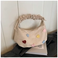 Detail of cream canvas bag featuring colorful heart patches and ruffled drawstring handle - Milk Tea
