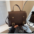 Gros plan détaillé du sac à dos vintage marron foncé avec boucle en métal doré et poche - café