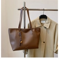 Dettaglio della borsa tote in pelle marrone scuro con scritte oro e ciondolo viola - Caffè con Ciondolo