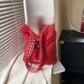 Red tweed tote bag with gingham lining and leather brand patch in lifestyle setting - Red