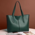 Primer plano del bolso tote verde oscuro con textura de cuero mate y costura vertical - Verde