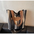 Detalle macro del bolso tote de lona a rayas con parche de cuero y remaches - Negro