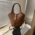Bruine suède bucket bag met leren bies en gouden draaisluiting in minimalistische stijl - Bruin