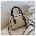 Dettaglio borsa retrò color crema con manici in pelle marrone e cerniera metallica oro - Patchwork Bianco e Nero Con Ciondolo