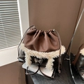 Dark brown leather and plush faux fur bucket bag featuring a silver butterfly buckle - Brown