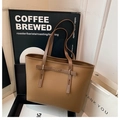 Dettaglio della borsa tote in pelle marrone martellata con fibbie dorate e lacci - Marrone