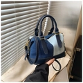 Dettaglio della borsa boston patchwork in denim con manici in pelle blu e hardware oro - Azzurro