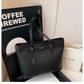 Dettaglio della borsa tote in pelle martellata nera con scritta dorata e cinturino - Nero