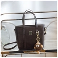Detail view of dark brown PU leather handbag featuring a cute monster charm and square metal tab - Coffee with Pendant