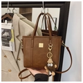 Detail view of brown vintage satchel with metal plate and plush monster keychain - Yellow Brown With Pendant