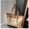 Dettaglio della borsa tote color crema con texture litchi e manici in pelle marrone - Bianco