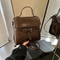 Dunkelbraune Vintage-Handtasche mit Schnallenriemen und Glanzoptik aus zwei Perspektiven - Braun