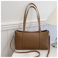 Detail shot of brown lychee grain leather tote bag with silver hardware on marble table - Brown