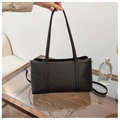 Dettaglio della borsa Boston nera in pelle martellata con manici lunghi e fibbie - Nero