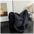 Macro shot of black quilted nylon puffer tote bag with diamond lattice pattern and soft texture - Black