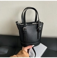 Detalle de bolso cubo de cuero granulado negro con herrajes plateados y correa ajustable - Negro