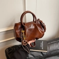 Bolso tipo cubo vintage plisado marrón caramelo con colgante de llave dorada - Marrón