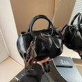 Elegante bolso bombonera plisado negro con asas redondas y refinados dijes de metal - Negro