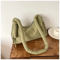 Detalle del bolso acolchado de nailon verde con correa de nudo sobre mesa - Verde