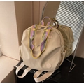 Detail eines beigen Nylon-Rucksacks mit buntem Webgurt und praktischer Seitentasche - Weiß und Lila