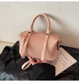 Detailansicht der hellrosa Faltenhandtasche mit vertikaler Textur und goldenen Beschlägen - Rosa