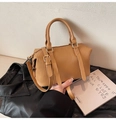 Nahaufnahme der braunen gefalteten PU-Lederstruktur einer stilvollen Boston-Handtasche - Khaki