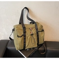 Détail du sac de voyage en nylon vert foncé avec sangles renforcées et ruban tricolore - Vert