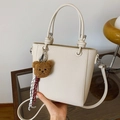 Chic cream-colored lychee leather bucket bag with knot handles and cute brown teddy charm - White