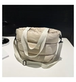 Détail du sac cabas matelassé avec larges anses blanches et texture en nylon crème - Kaki