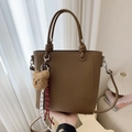 Brown leather bucket bag with handle, crossbody strap and plush bear accessory - Brown