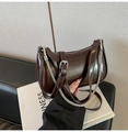 Detalle del bolso hobo marrón oscuro brillante con cadena plateada y acabado de cuero - Marrón