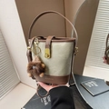 Retro sage green canvas bucket bag with brown leather trim and fuzzy monster charm - With Charm / Tan