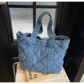 Detalle de bolso tote de mezclilla acolchada con patrón de diamantes azules y textura - Azul oscuro